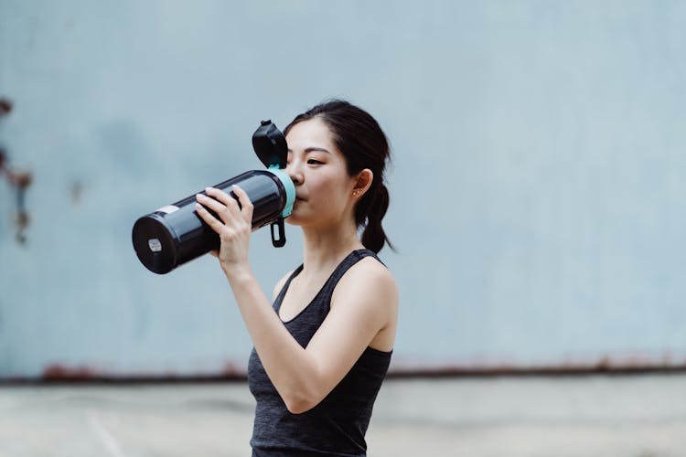 Young Woman Drinking Water From Drinking Flask