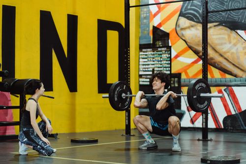 Free Man weightlifting in a colorful urban gym, showcasing strength and focus. Stock Photo