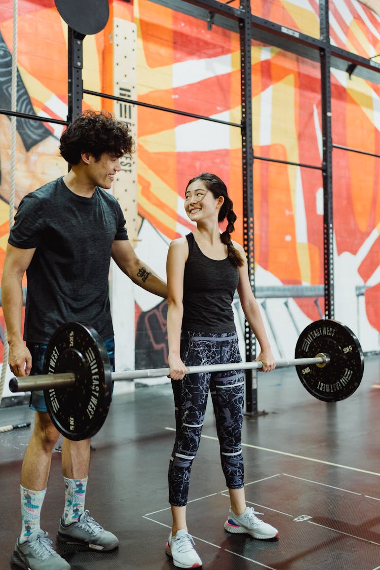 Man And Woman Exercise Together With Weights