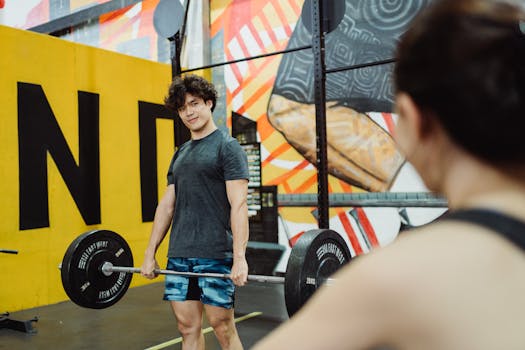 Two adults engaged in weightlifting at a vibrant gym setting, highlighting strength and fitness.