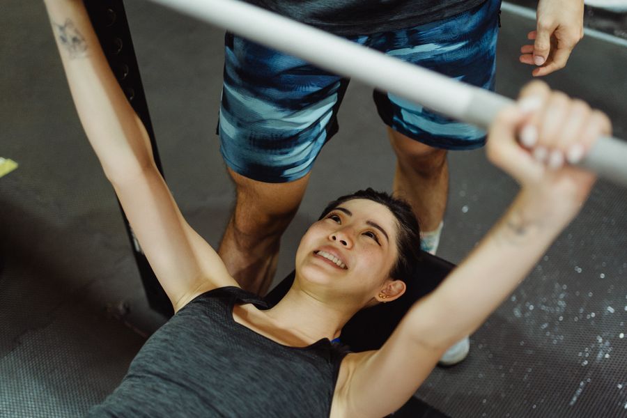 Personal trainer coaching a client through bench press at One World Fitness