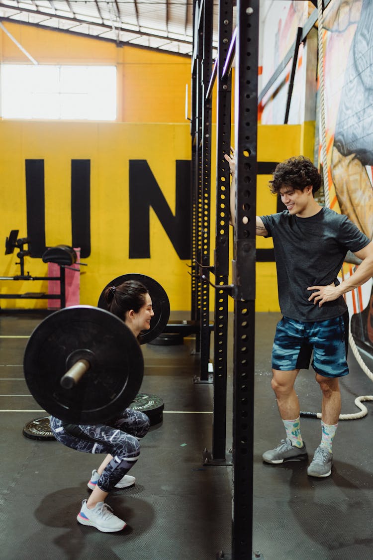 Man And Woman Exercise Together With Weights