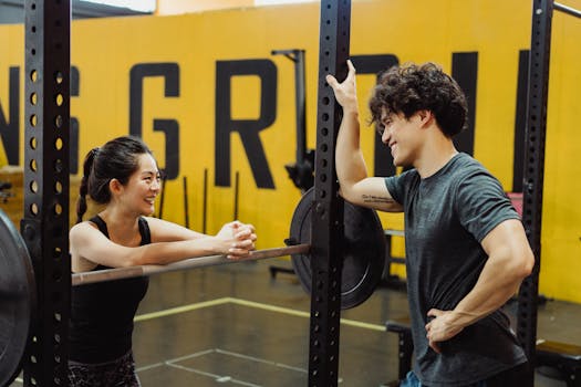 Two friends engage in lively conversation and fitness at the gym, showcasing camaraderie and healthy lifestyle.
