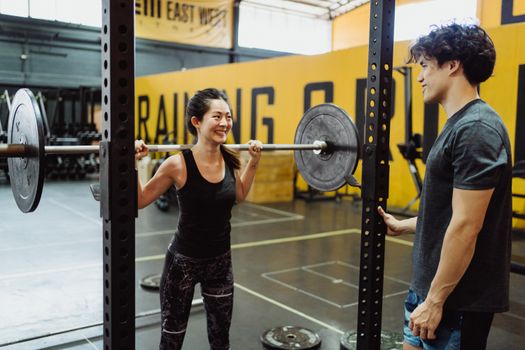 A couple working out together at the gym, weightlifting and enjoying an active lifestyle.
