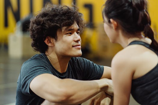 A young couple connects face-to-face in an intimate gym setting, fostering closeness and understanding.