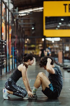 Energetic young couple in activewear doing sit ups at a modern gym.