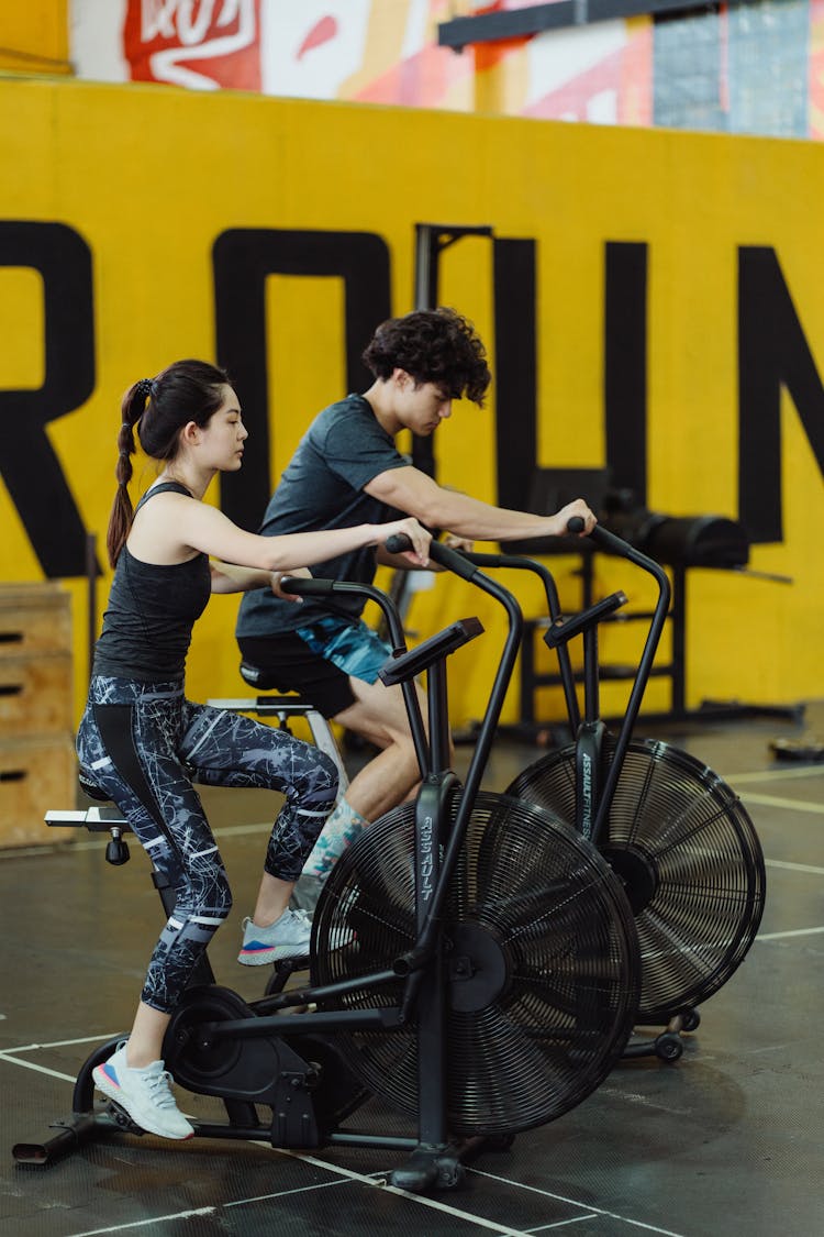 A Couple Using Elliptical Trainers