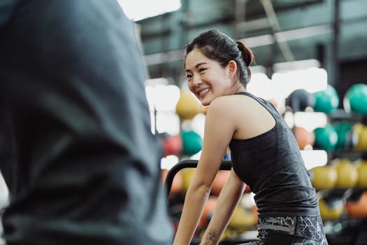 Smiling woman in a gym setting, promoting healthy lifestyle and fitness.