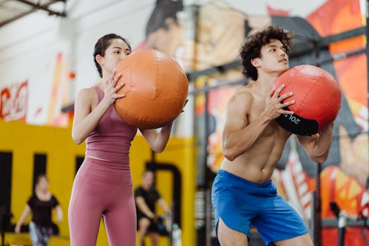Young adults working out with medicine balls in a modern gym environment, focusing on fitness and teamwork.