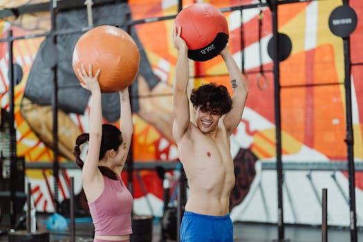 Fit couple working out with medicine balls in a vibrant gym setting.