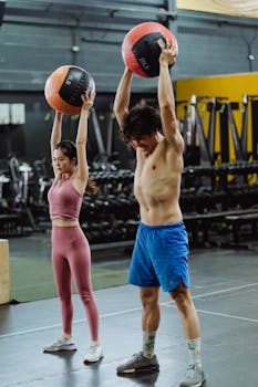 A couple engages in a vigorous workout with medicine balls at the gym, enhancing fitness and strength.