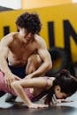 A Man Assisting a Woman in Doing Push Ups