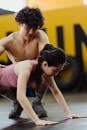 A Man Assisting a Woman in Doing Push Ups