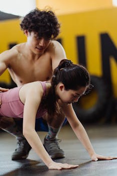 Asian man and woman working out together, performing push-ups indoors.