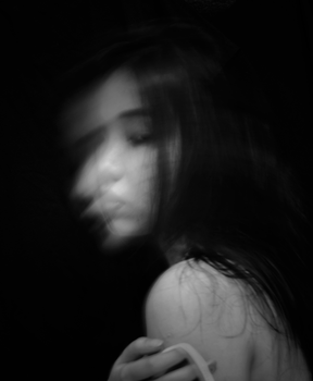 A mysterious black and white portrait of a woman with a blurred face, creating an ethereal and artistic mood.