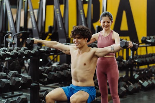 Man lifting weights under supervision in a gym, embracing fitness and determination.