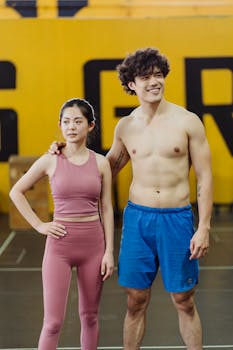 Male and female athletes posing confidently in a gym environment