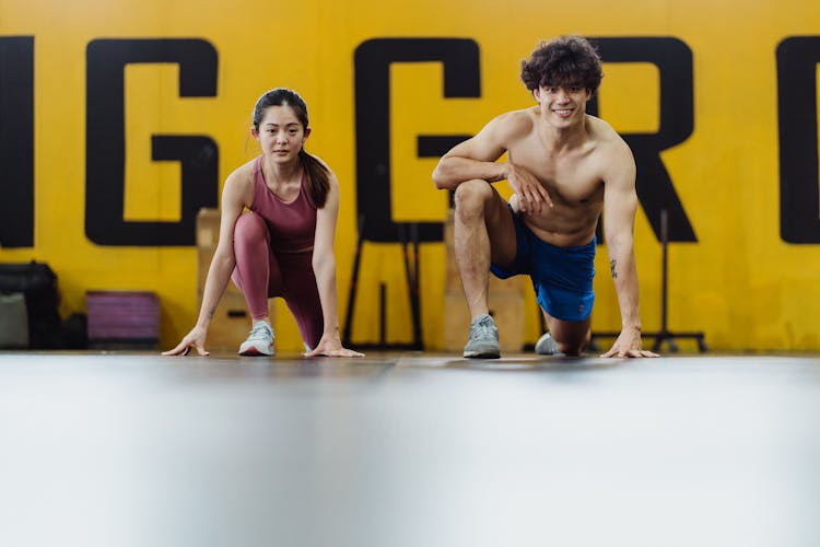 Man And Woman Crouching In Gym