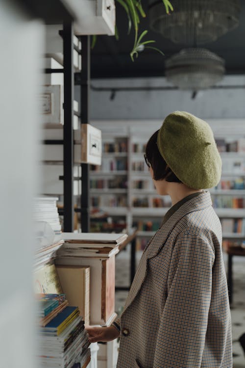 茶色の木製テーブルの近くに立っている茶色の帽子の女性