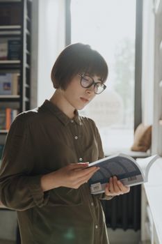 阳光明媚的图书馆里，一位年轻女子正在读书，拥抱教育和知识