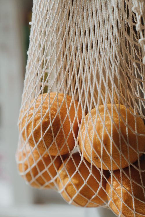 Free Close-up of oranges in an eco-friendly string bag, highlighting sustainable shopping and zero waste lifestyle. Stock Photo