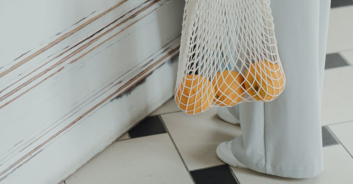 A woman carries oranges in a reusable string bag, reflecting zero waste lifestyle.