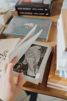 在舒适的环境里，翻阅一本带有复杂鸟类插图的手工书