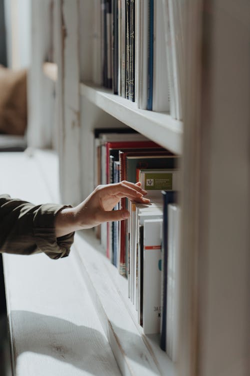 Orang Dengan Buku Memegang Kemeja Lengan Panjang Hitam