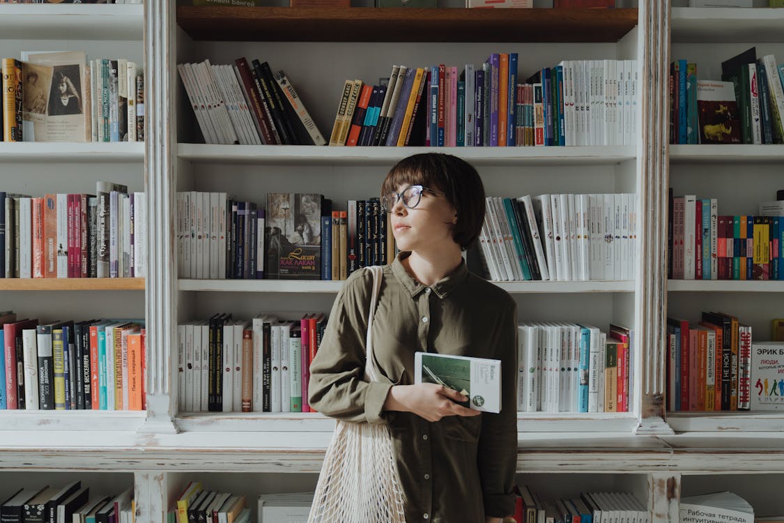 Woman in Green Coat Holding Book