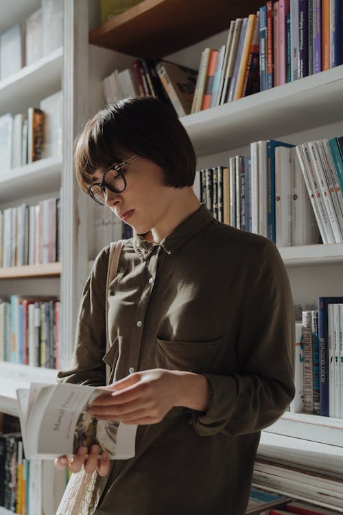 Woman in Brown Coat Reading Book