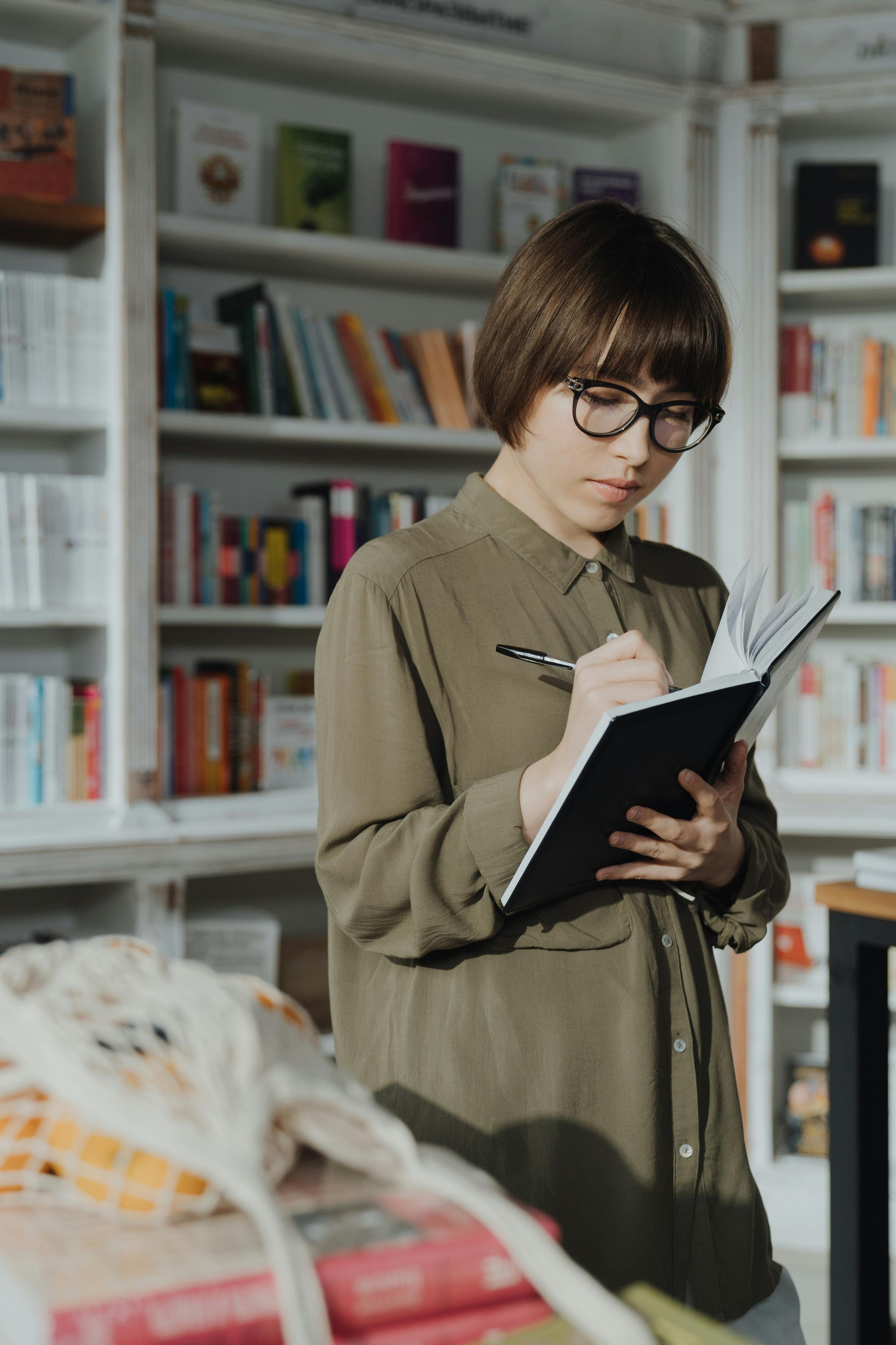 woman in brown coat holding book