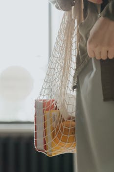 特写镜头展示了一个可重复使用的细绳袋，里面装着书籍和水果，倡导零浪费