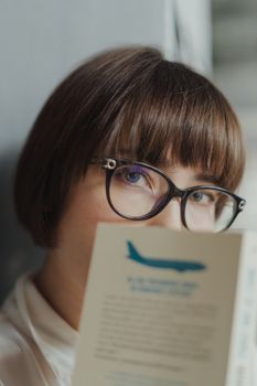 一位戴眼镜的女人在室内凝视着一幅肖像画