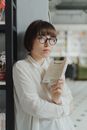 一位戴眼镜的女人在图书馆里阅读，探索文学