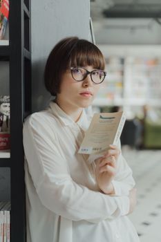 一位戴眼镜的女人在图书馆里阅读，探索文学