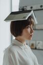 室内，一名妇女的肖像中，她头上平衡着一本书