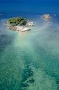 Tropical islet in azure shallow sea