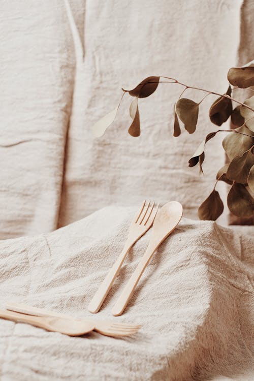 Photo of Wooden Fork and Spoon Near Leaves