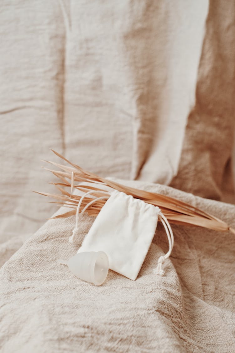 Photo Of A Menstrual Cup Beside A White Pouch