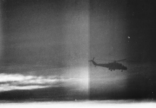 Free Atmospheric black and white photo of a military helicopter silhouette against a dramatic cloudy sky. Stock Photo