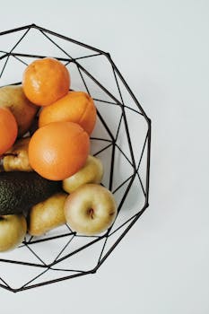 A top view of assorted fresh fruits in a modern wire basket, showcasing a healthy lifestyle.