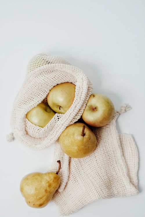 Free Top view of ripe pears in an eco-friendly reusable mesh bag on a white background. Stock Photo