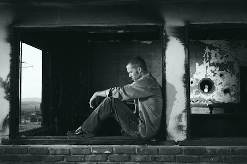 бесплатная Фотография сидящего человека в оттенках серого Стоковое фото