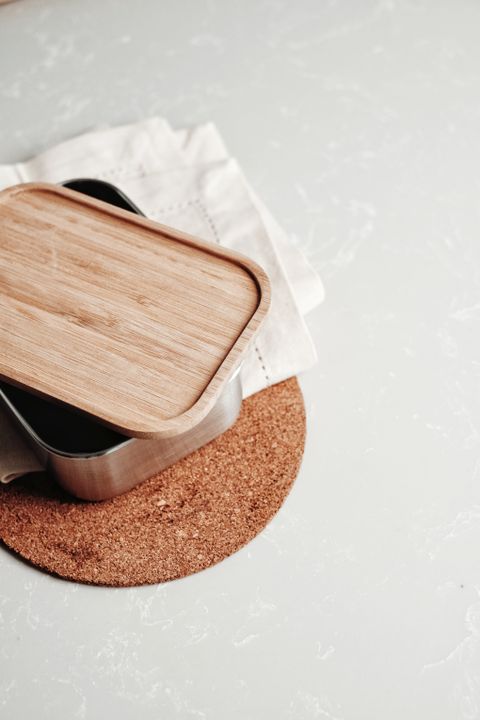 Steel lunch box with a bamboo lid on a cork mat