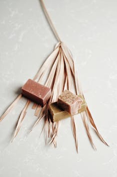 Three eco-friendly bar soaps displayed on a dried leaf, highlighting sustainable skincare.