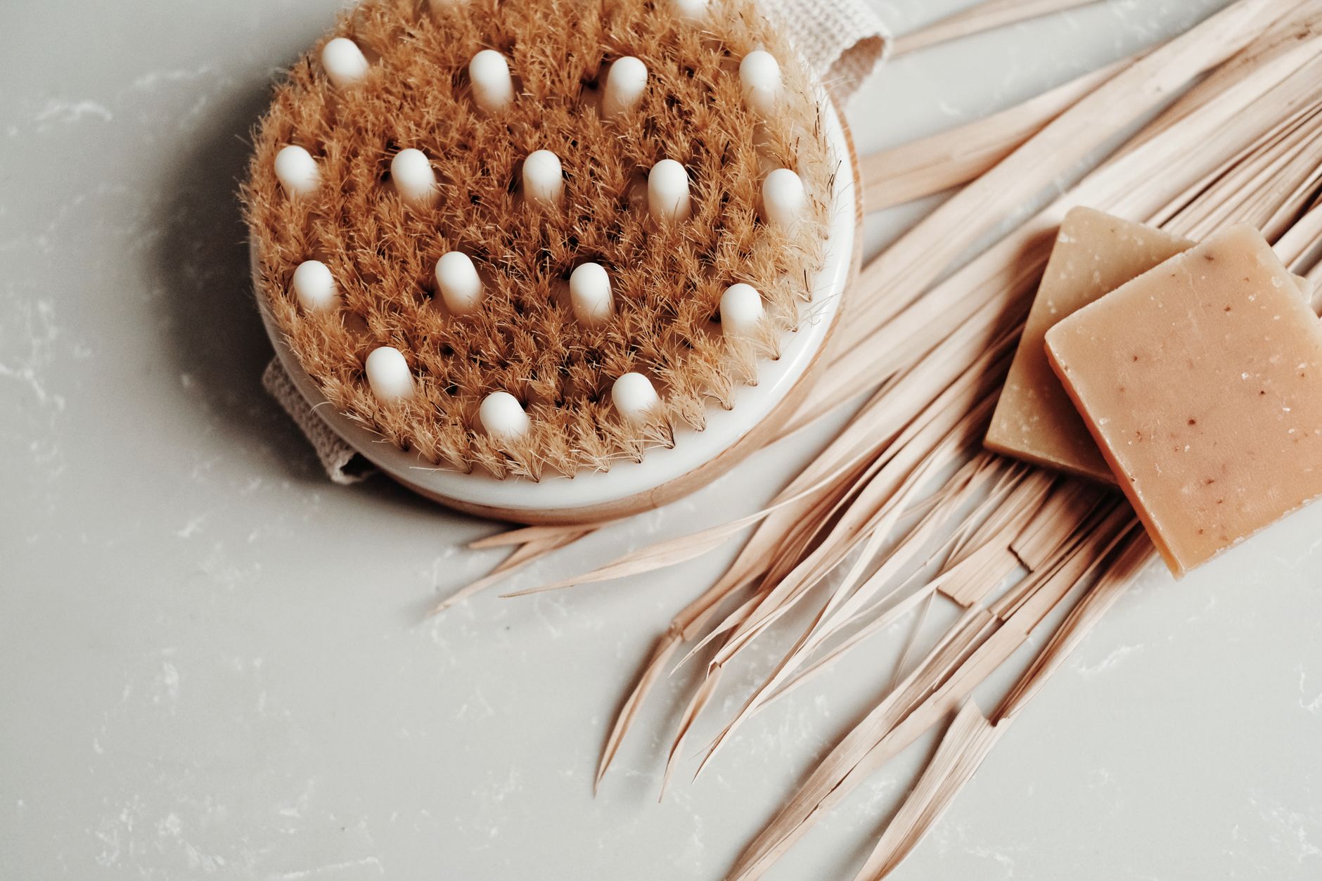 Eco-friendly body brush and soap on marble, promoting sustainable hygiene practices.