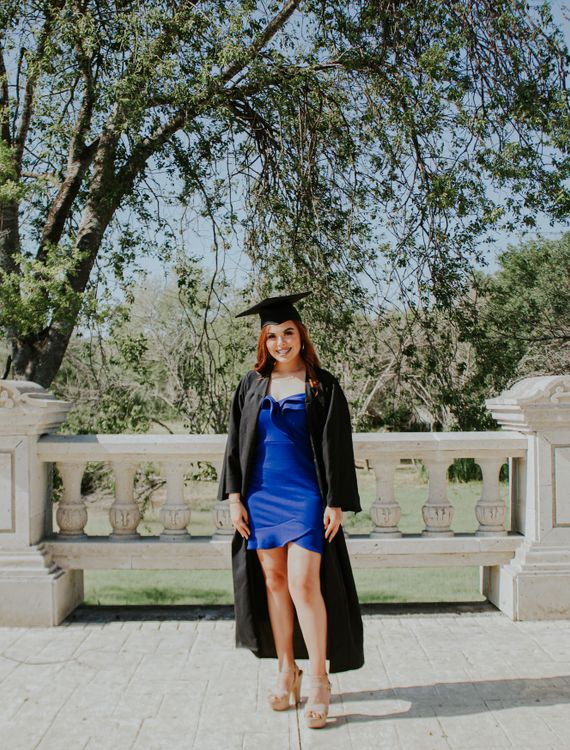 Cheerful graduate in dress and cloak Free Stock Photo Cheerful graduate in dress and cloak Free Stock Photo