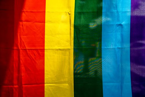 Free Background of multicolored rainbow flag with stripe ornament made of textile with creased surface in daytime Stock Photo