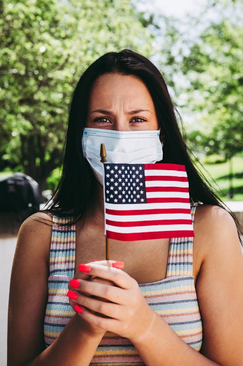 Anonymous woman in mask with American flag on Independence Day