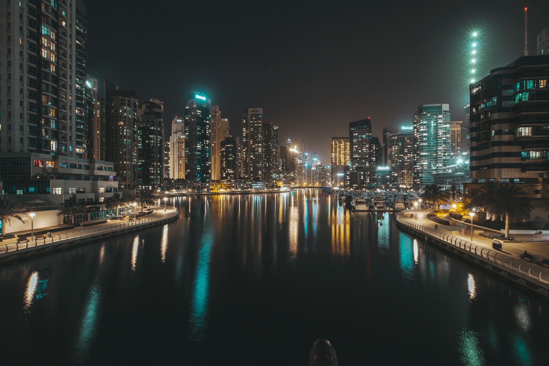 Explore the mesmerizing Dubai Marina skyline at night with illuminated high-rises and tranquil waters.